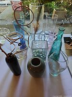 Group shot of all glass and ceramic vases and bottles on table