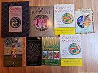 Front covers of seven paperback books on wood surface