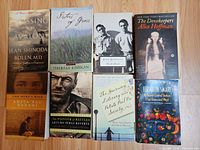 Eight trade paperback books arranged on floor showing all covers