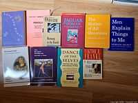 All ten paperback books laid out on wood surface, titles visible