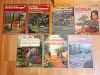 Seven of the eight gardening paperbacks laid out showing front covers