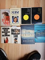 Group shot of all eight paperback books arranged on floor