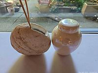 Iridescent glass vase and shell-form ceramic vase side by side