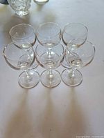six clear cordial glasses grouped on table