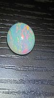 Front view of oval opal showing multicolour play