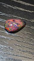 Pear-shaped opal cabochon front view, vivid play-of-color visible