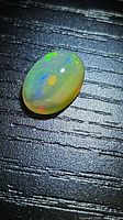 Opal showing multicolored play of color on dark background