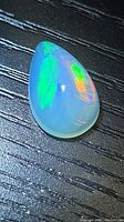 Pear cabochon opal showing green and orange flash