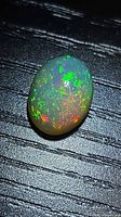Oblique view showing full face of opal with pinfire play of colour