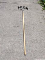 Full view of bow rake laid on concrete showing entire length