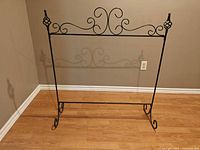 Full view of freestanding black metal stocking holder stand on floor