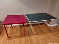 Red square and green rectangular folding tables standing