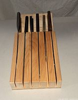 Wooden knife block with six knives inserted