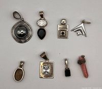 Front view of eight assorted sterling pendants displaying stones and shapes