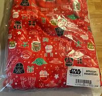 Front view of sealed red Star Wars pajama top showing pattern and label