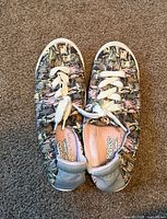 Top view of both sneakers showing cat print uppers and laces