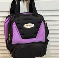 Front view of black and purple Columbia 300 bowling bag showing badge, zip compartments and molded bottom