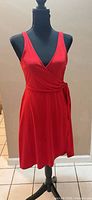 Front view of red sleeveless wrap dress on mannequin