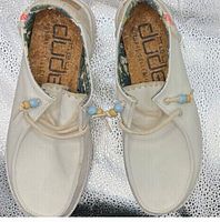 Top view of both shoes showing canvas uppers, cork insoles, bead-toggled laces