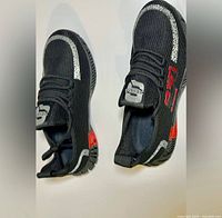 Top view of both sneakers showing knit upper, laces, reflective strip, red accents