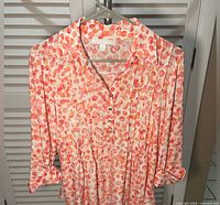 Front view of Juniper + Lime abstract dot blouse on hanger