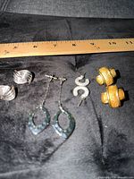 All four pairs of earrings with ruler for scale