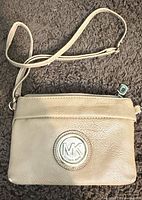 Front view showing color, texture, strap, and MK logo plaque