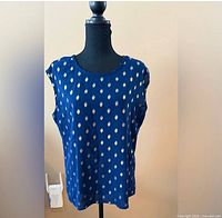 Front of navy gold polka-dot sleeveless blouse on mannequin