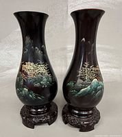 Front view of both lacquer vases on stands showing painted landscapes