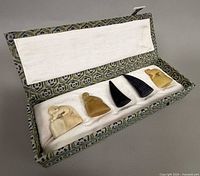 Open brocade box showing five seals in padding