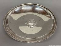 Top view of silver plated shallow bowl showing beaded rim and central crest