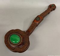 Full view of carved Ruyi showing head and handle with green stone insets