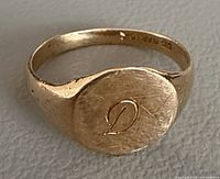 Top view of yellow gold signet ring showing engraved D on oval bezel