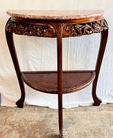 Front angled view displaying marble top, carved apron, legs