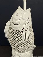 Close-up of ceramic koi fish body showing reticulated lattice and sculpted detail