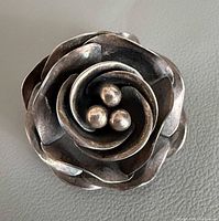 Front view showing layered rose petals and bead stamens