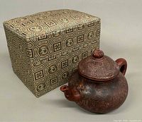 teapot next to patterned brocade box
