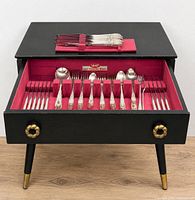 Open drawer showing full 65-piece flatware set and interior lining