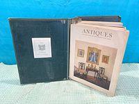 Binder open showing front inside cover and one magazine's front cover