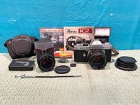Full lot overview showing camera with lens, flash, case, second items, manuals, filters, cable release and accessories