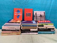 Overview of 31 assorted sports and culture books arranged in three stacks
