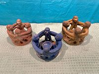 Group shot of three circle-of-friends sculptures in blue, red and sand colours