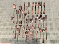 Full lot showing assorted forks and spoons laid out on cloth