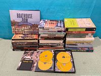 Group view of all 28 books stacked in two columns with open Nine for IX DVD case in foreground