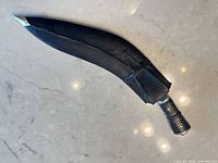 Knife fully sheathed showing exterior profile and handle pommel
