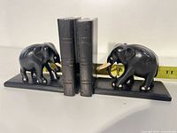 Front view of both elephant bookends with measuring tape for scale