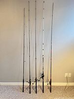Five fishing rods standing upright side by side