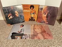 Group shot of five LP covers standing on carpet