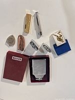 Group shot of all ten lighters and Ronson box