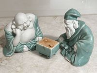 Front view of Buddha and Confucius figurines with game board